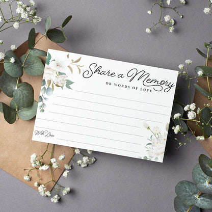 cardamonoly share a memory or words of love card on grey desk with olive foliage, small white flowers and kraft envelope